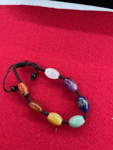 A bracelet with different colored stones on it.