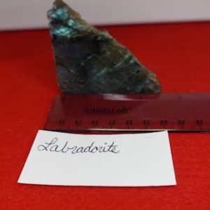 A piece of green stone sitting on top of a red surface.