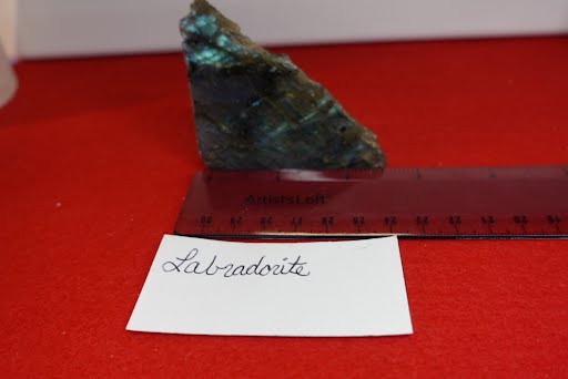A piece of green stone sitting on top of a red surface.