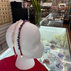 A mannequin head with jewelry on display in front of it.