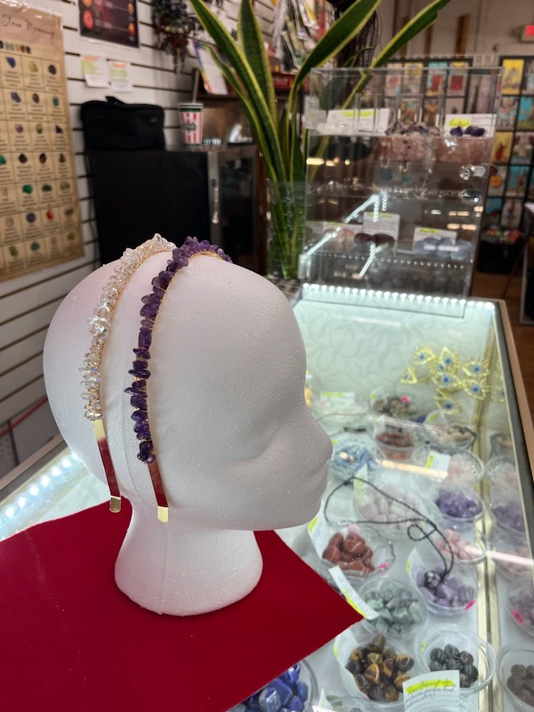 A mannequin head with jewelry on display in front of it.