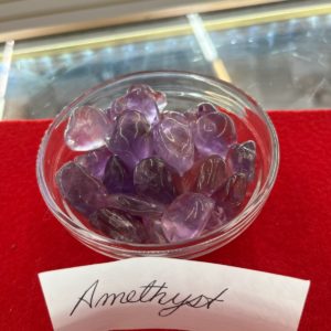 A bowl of amethyst on top of a red table.