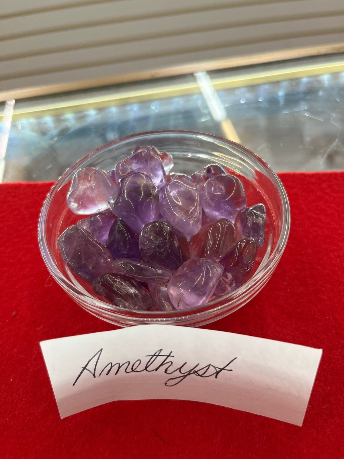 A bowl of amethyst on top of a red table.