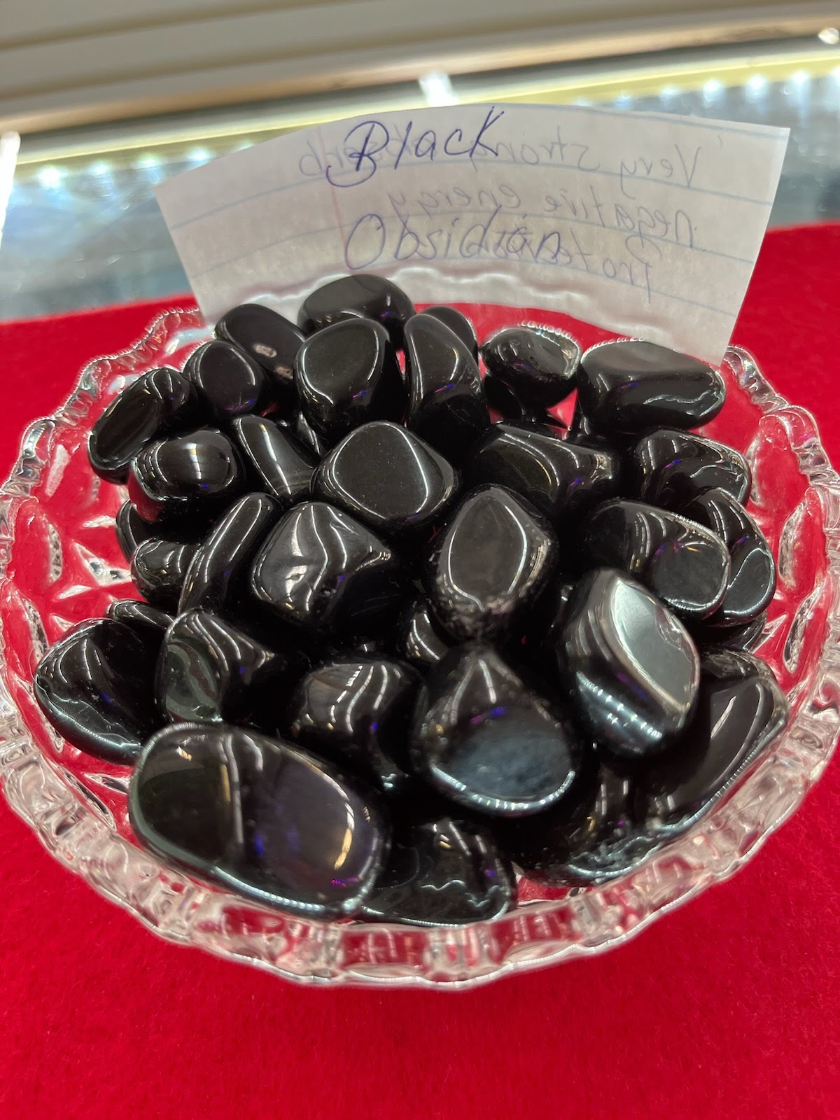 A bowl of black rocks on top of a red table.