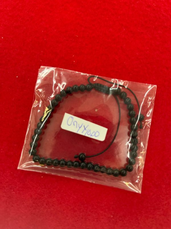 A package of beads on top of a red table.