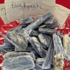 A pile of blue kyanite on top of a red table.