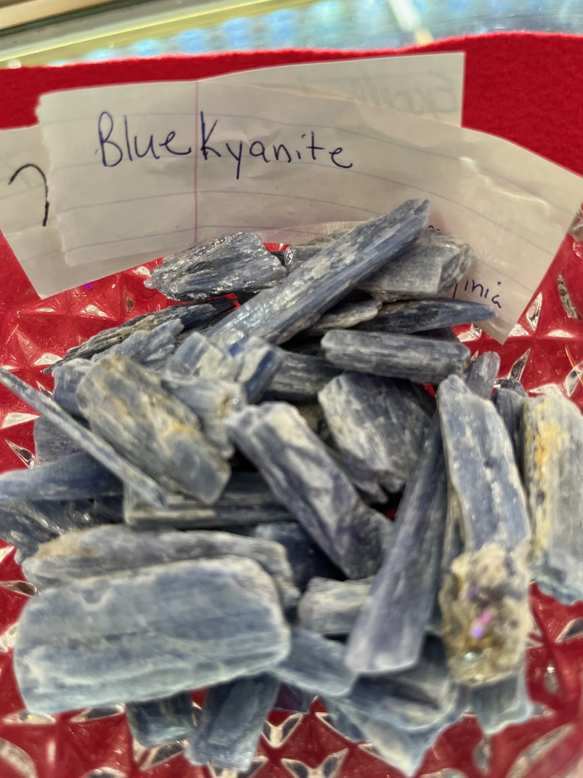 A pile of blue kyanite on top of a red table.