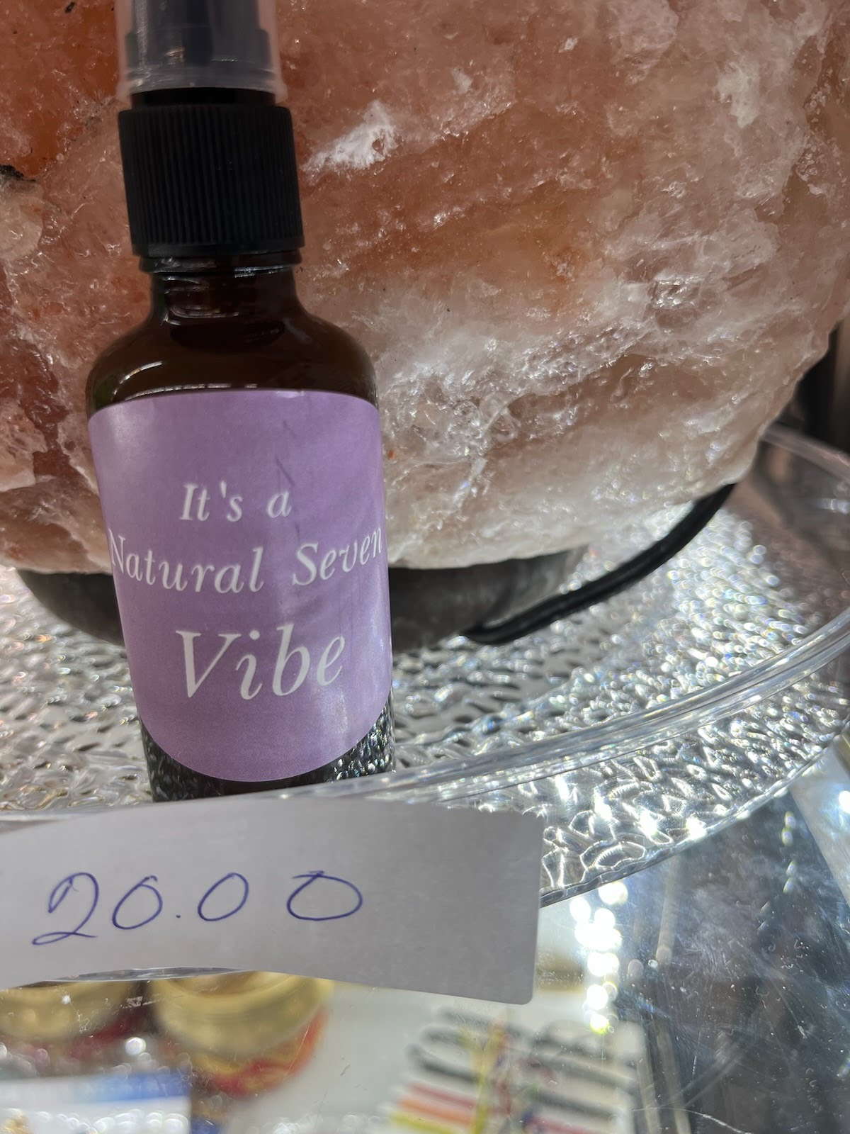 A bottle of lavender oil sitting next to a rock.