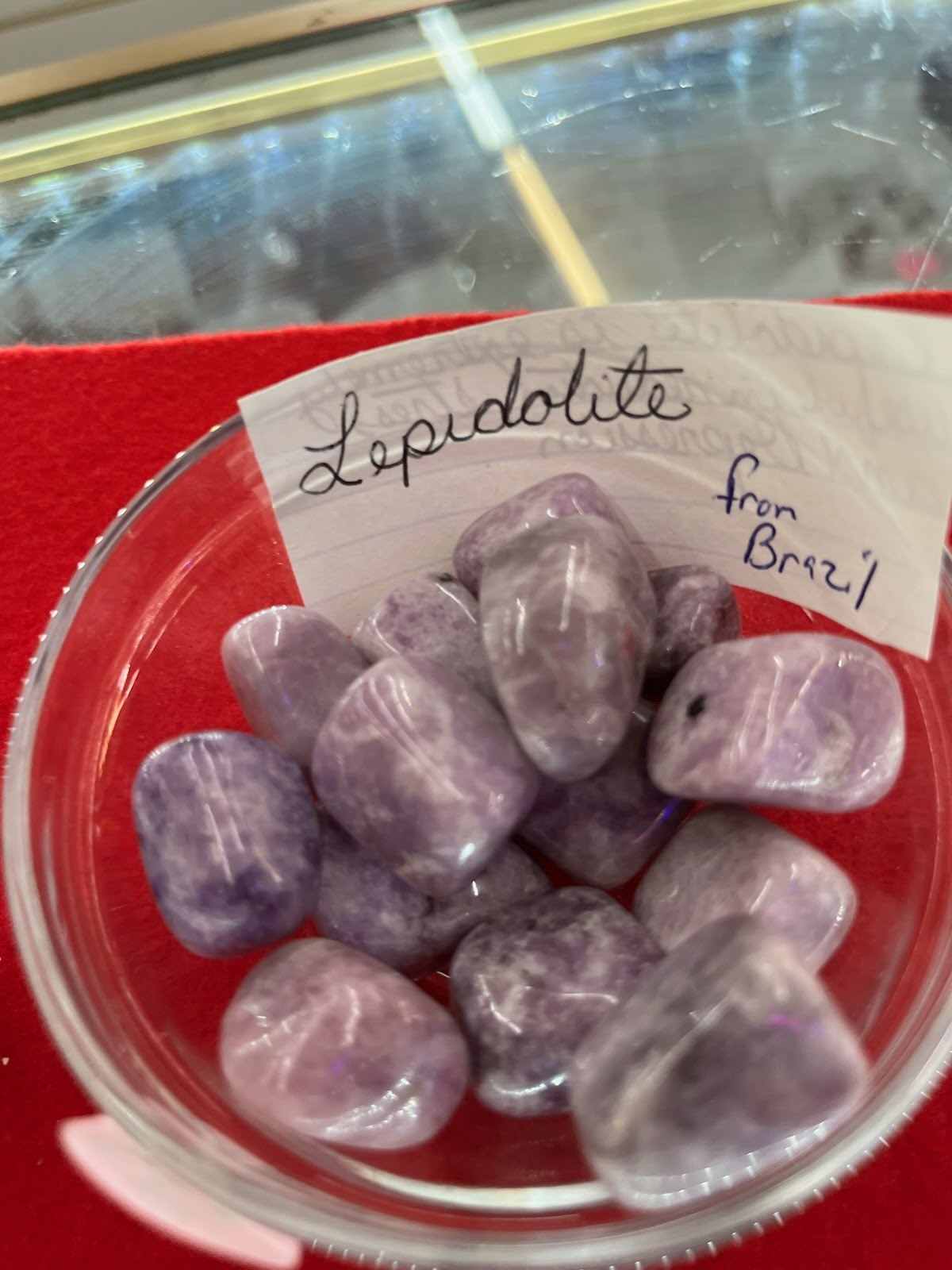 A bowl of purple and white rocks with a note on the side.