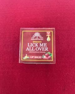 A red box of lip balm with the words " lick me all over ".