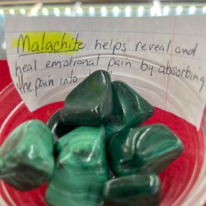 A bowl of malachite with a note on it.