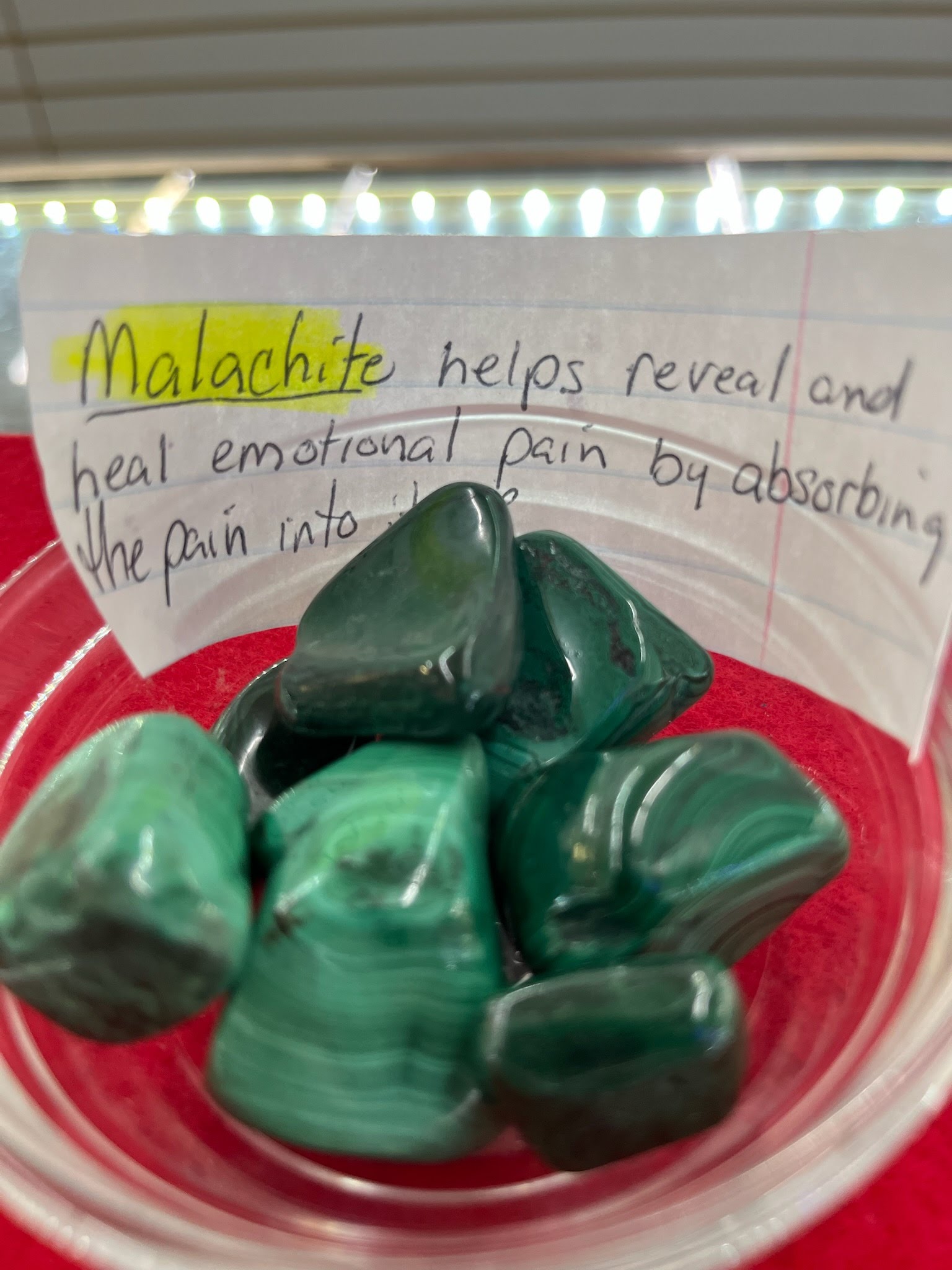 A bowl of malachite with a note on it.