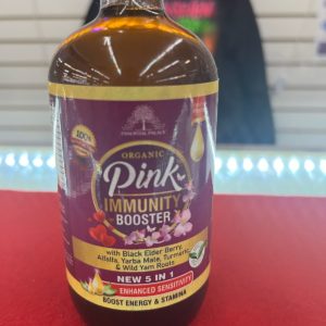 A bottle of pink immunity booster on a table.