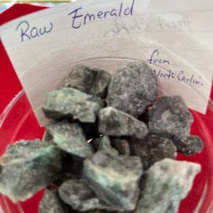 A cup of raw emerald is on the table.