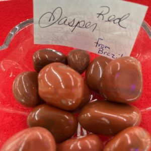 A red plate with some chocolate covered raspberries