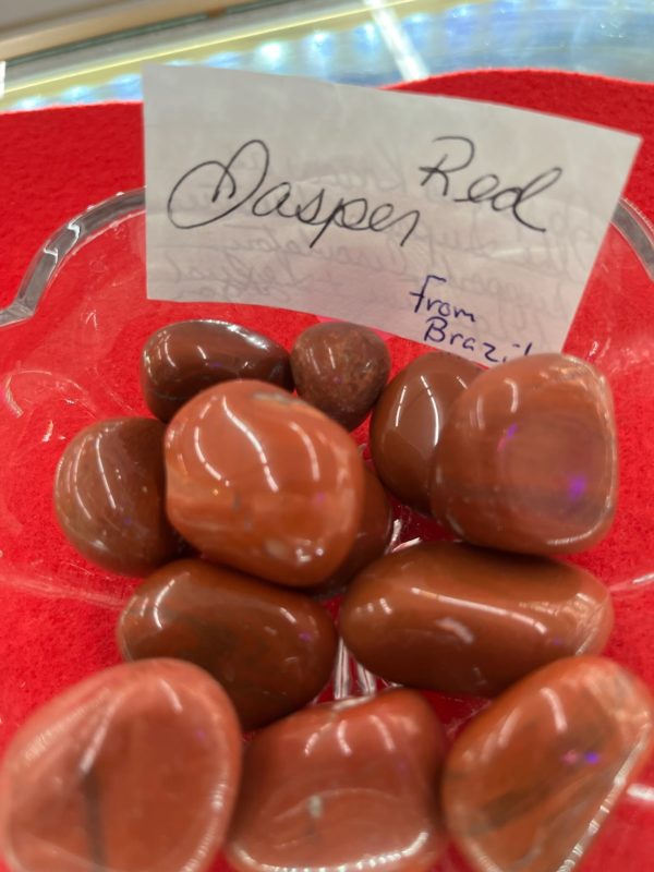 A red plate with some chocolate covered raspberries