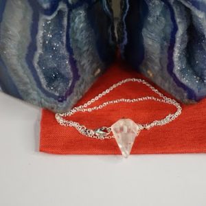 A necklace that is sitting on top of a red bag.