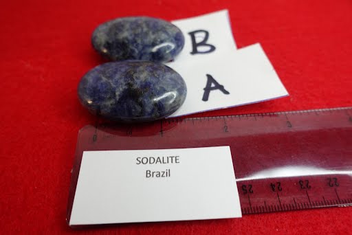 A pair of sodalite stones with a ruler and name card.