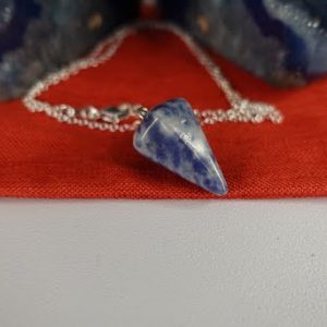 A blue and white porcelain necklace on a red cloth.