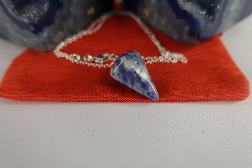 A blue and white porcelain necklace on a red cloth.