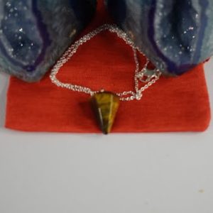 A necklace that is on top of a red bag.