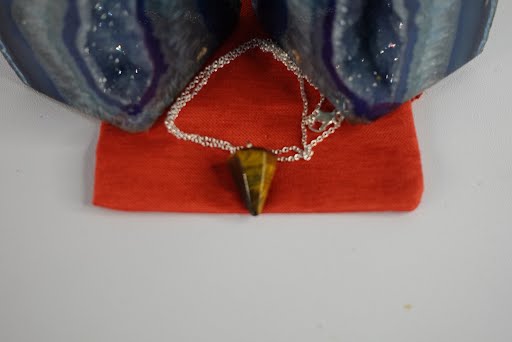 A necklace that is on top of a red bag.